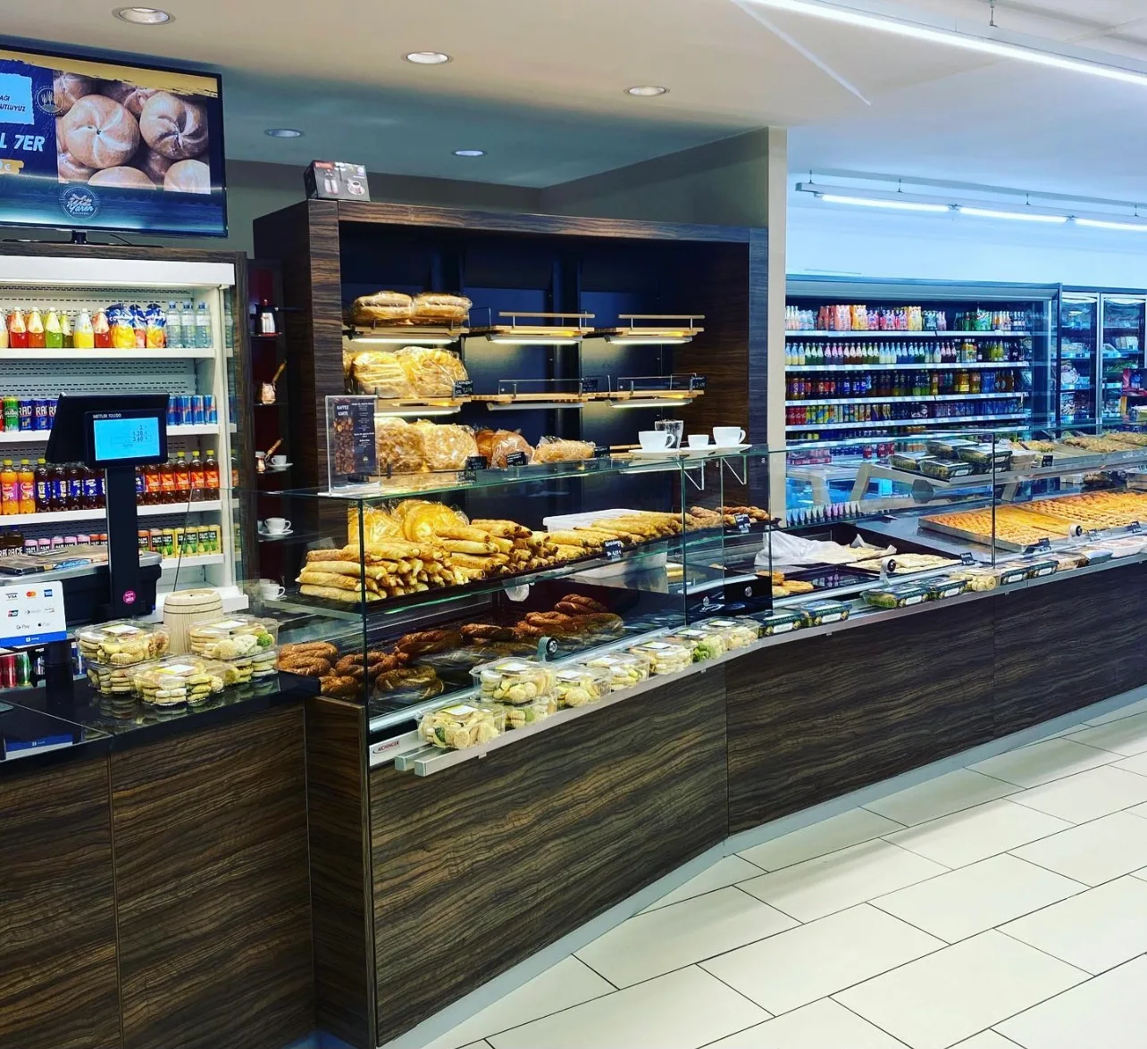 Die Backwaren- und Feinkosttheke mit Simit, Blätterteiggebäck und Baklava, dahinter das Getränkeregal