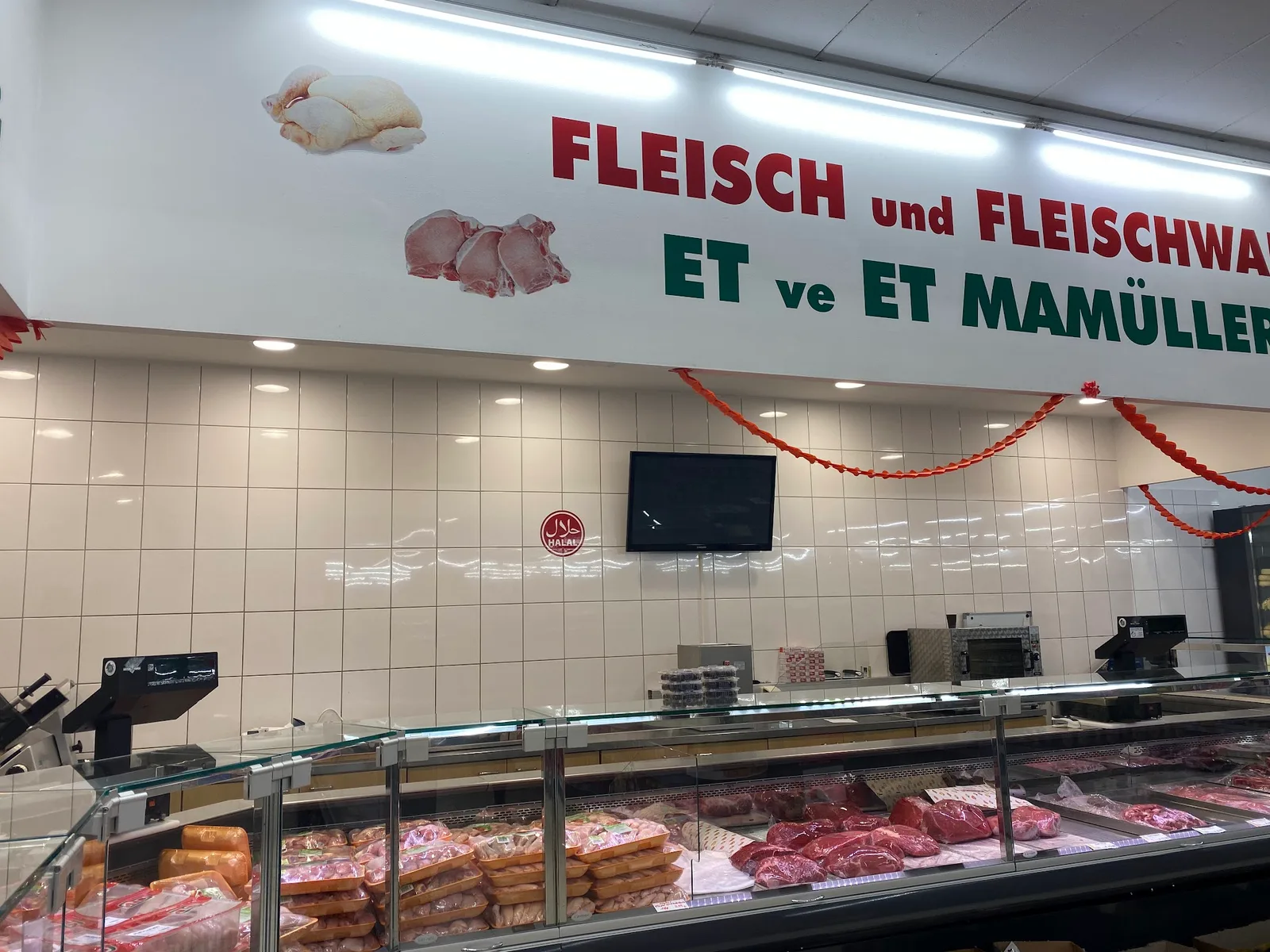Die Fleischtheke, darüber die Wandbeschriftung Fleisch und Fleischwaren, ET ve ET MAMÜLLERİ, daneben ein Halal-Siegel